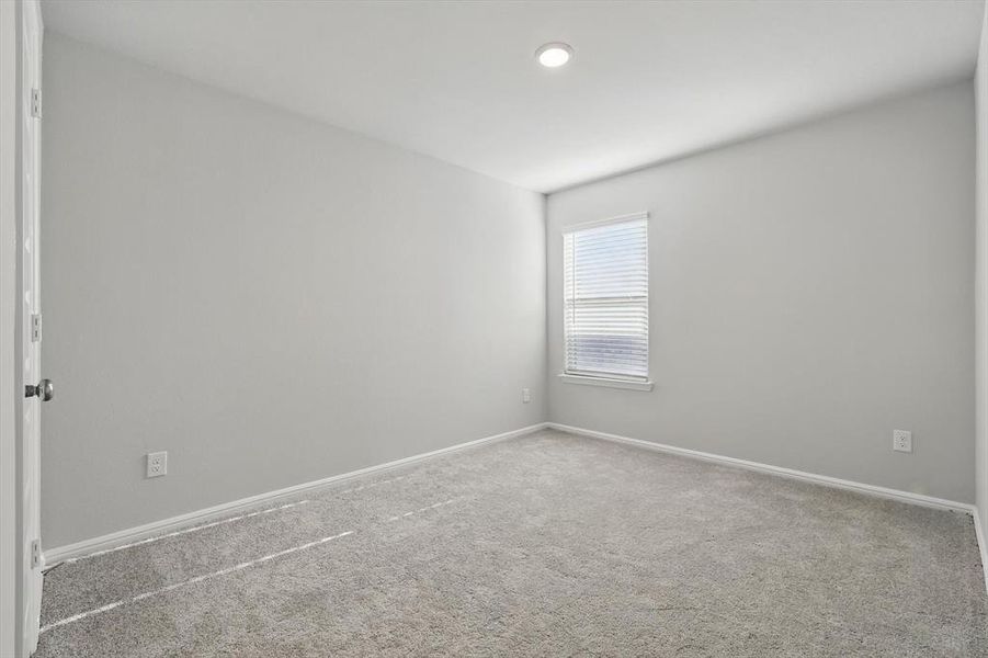 Empty room with carpet flooring and baseboards Empty room with carpet flooring and baseboards