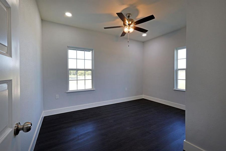 Spare room featuring dark wood-type flooring, plenty of natural light, recessed lighting, and ceiling fan Spare room featuring dark wood-type flooring, plenty of natural light, recessed lighting, and ceiling fan