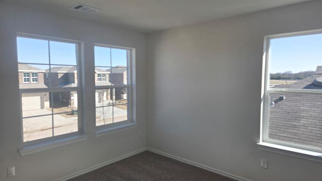 Spare room with dark carpet and baseboards