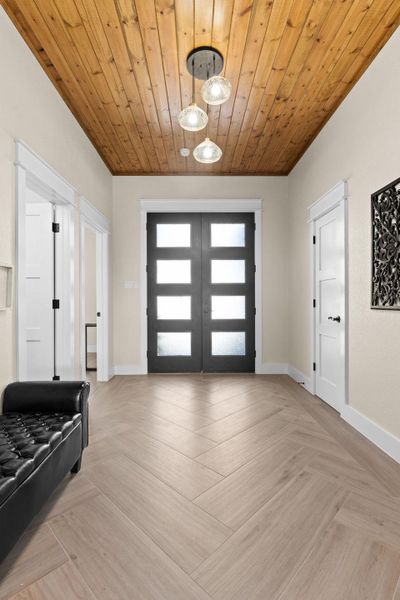 Foyer featuring french doors, baseboards, and wood ceiling Foyer featuring french doors, baseboards, and wood ceiling