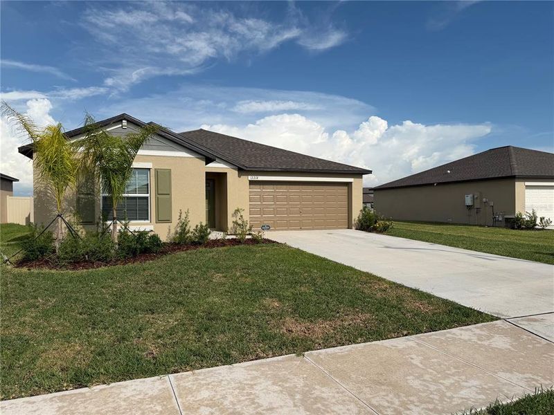 Front exterior of a new home in Prosperity Lakes, Parrish, FL, highlighting curb appeal (Image 2).