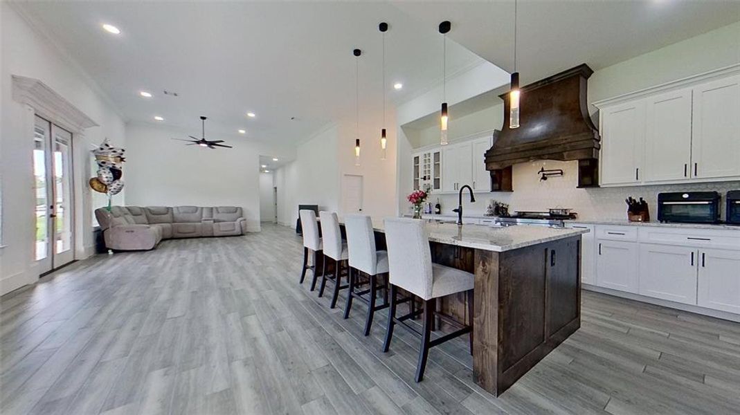 Modern kitchen and living area featuring wood-finish tile flooring throughout Modern kitchen and living area featuring wood-finish tile flooring throughout