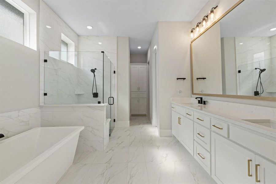 Full bath with a marble finish shower, a freestanding tub, double vanity, marble finish floors, and recessed lighting