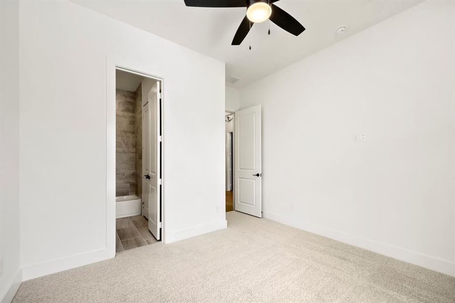Bright interior room with plush carpeting, crisp white walls, and a contemporary ceiling fan with integrated lighting Bright interior room with plush carpeting, crisp white walls, and a contemporary ceiling fan with integrated lighting