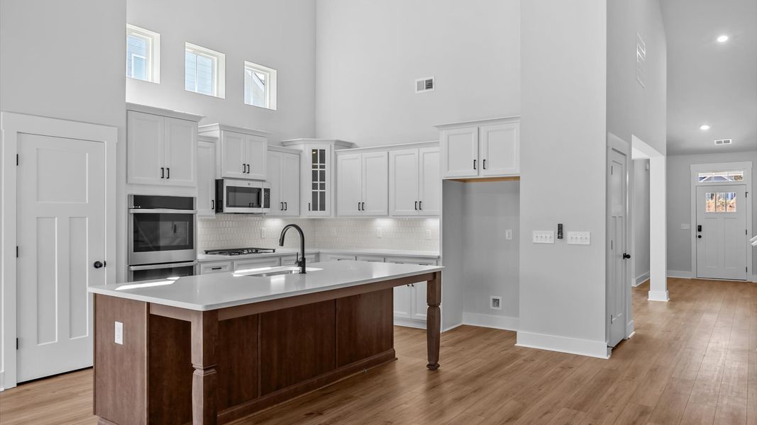 Highly skilled kitchen design includes a 9-foot island, quartz countertops, and vaulted ceilings