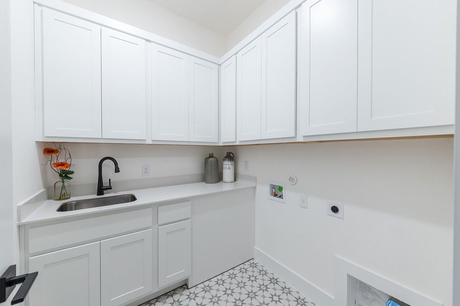 Laundry room with sink, ample built Kent Moore cabinets, washer and dryer hookup