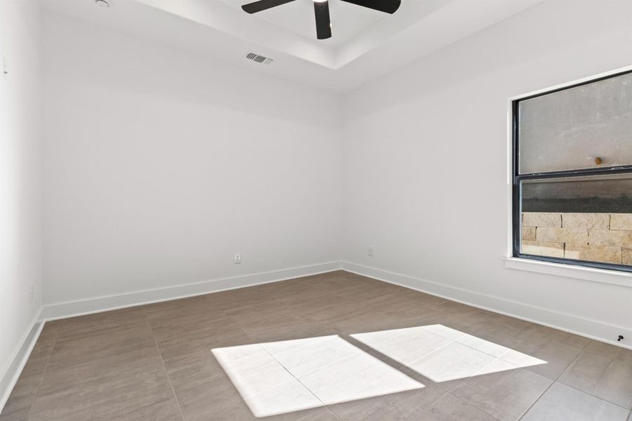 Unfurnished room featuring baseboards and a raised ceiling