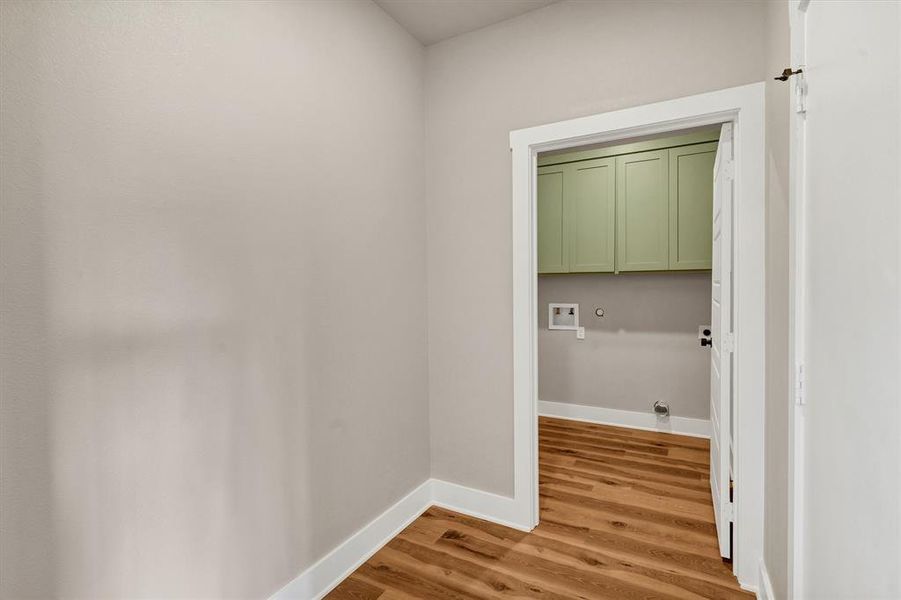 Laundry area featuring hookup for a gas dryer, light wood finished floors, cabinet space, and washer hookup Laundry area featuring hookup for a gas dryer, light wood finished floors, cabinet space, and washer hookup
