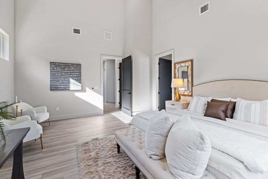 Bedroom with light wood-type flooring, visible vents, and baseboards