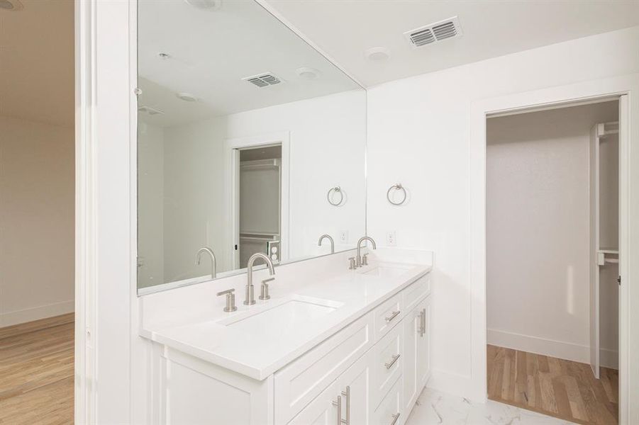 Full bath featuring a sink, visible vents, and baseboards