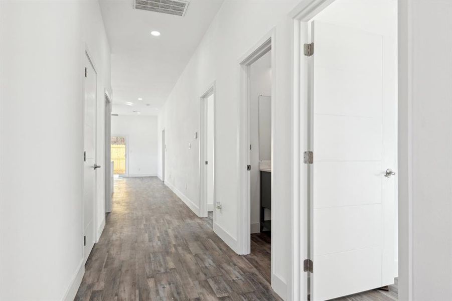 Hall featuring baseboards, visible vents, wood finished floors, and recessed lighting