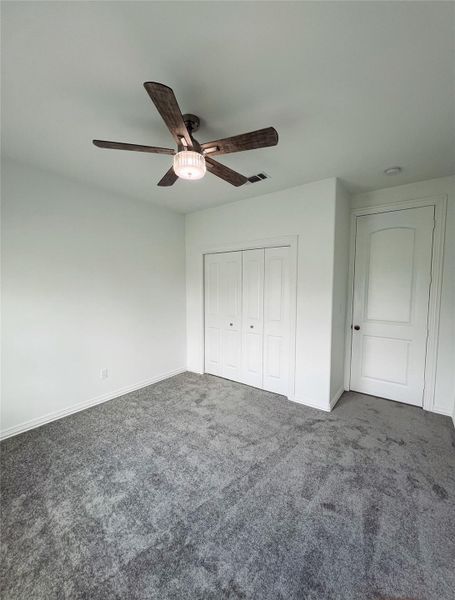 Unfurnished bedroom with visible vents, carpet floors, a closet, baseboards, and ceiling fan Unfurnished bedroom with visible vents, carpet floors, a closet, baseboards, and ceiling fan