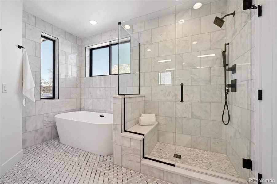 Spa-style primary suite with soaking tub