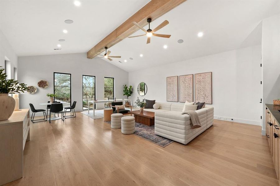 Living room with light wood-type flooring, beam ceiling, recessed lighting, and high vaulted ceiling Living room with light wood-type flooring, beam ceiling, recessed lighting, and high vaulted ceiling
