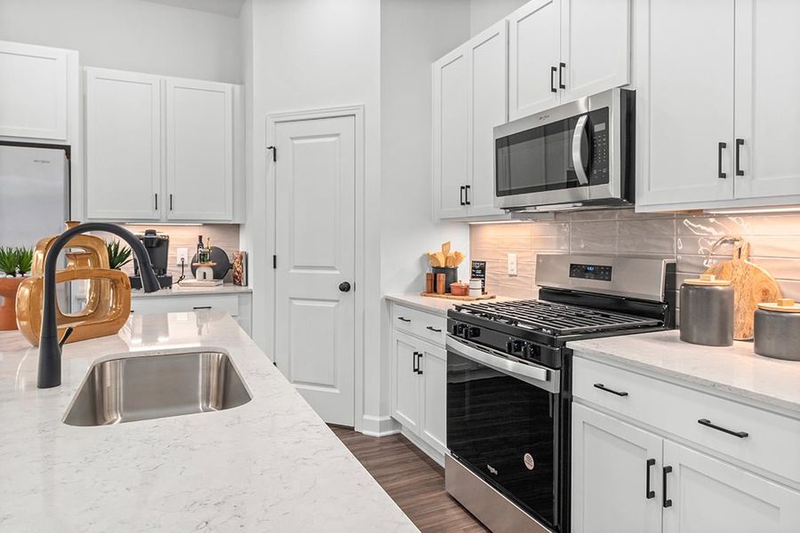 A kitchen with white cabinets.