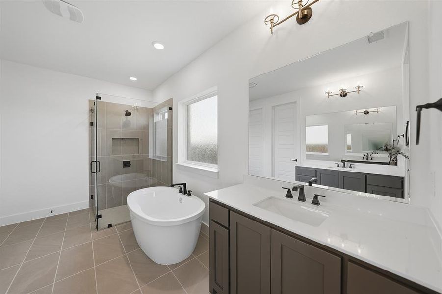 Bathroom with vanity, a freestanding tub, a shower stall, light tile patterned flooring, and recessed lighting Bathroom with vanity, a freestanding tub, a shower stall, light tile patterned flooring, and recessed lighting