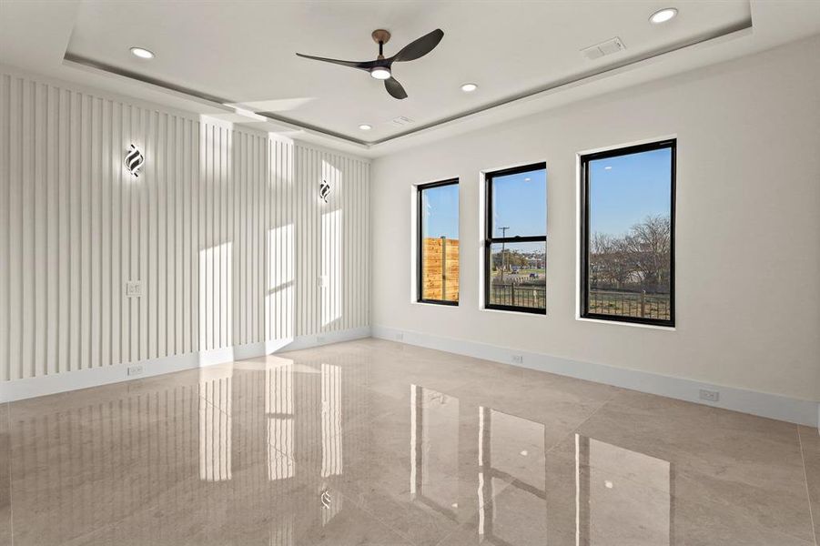 Unfurnished room with a tray ceiling and ceiling fan