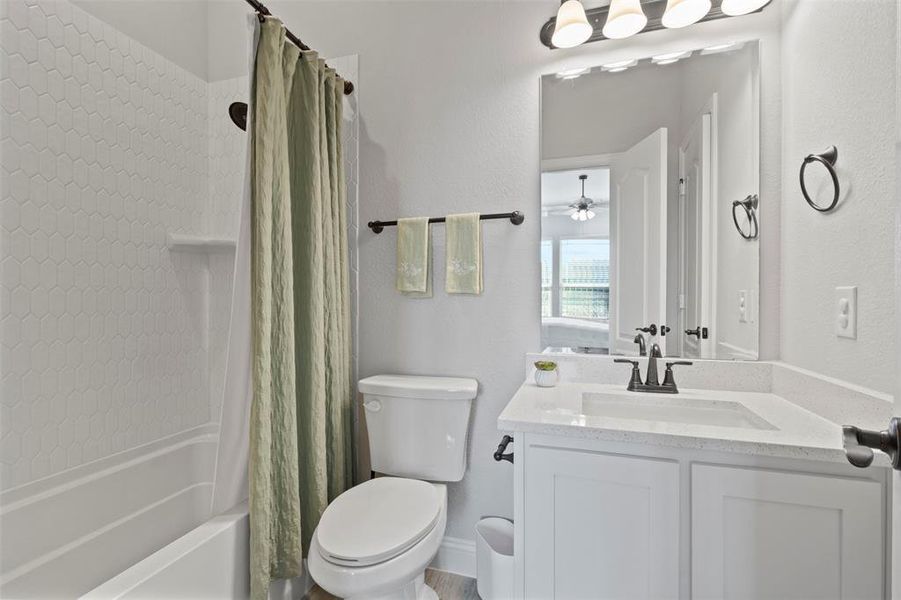 Full bathroom with shower / tub combo with curtain, toilet, and vanity