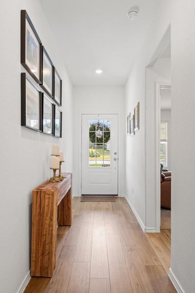 A welcoming entry hall with warm woodtone LVP flooring opens to sun-filled interior. A welcoming entry hall with warm woodtone LVP flooring opens to sun-filled interior.