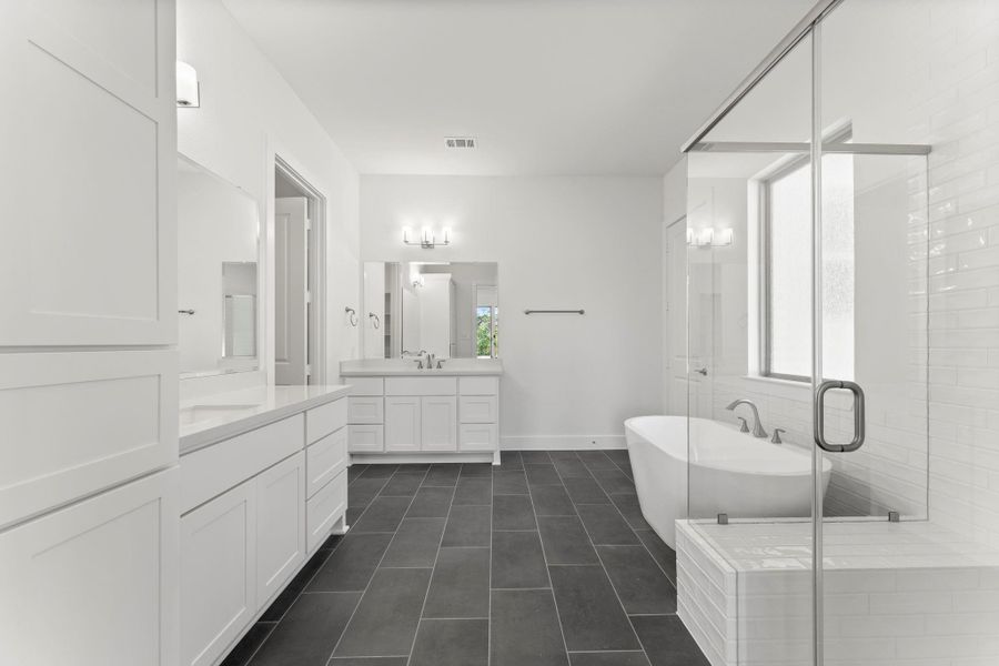 Spacious primary bathroom with dual vanities, extra built-ins, and tile flooring Spacious primary bathroom with dual vanities, extra built-ins, and tile flooring