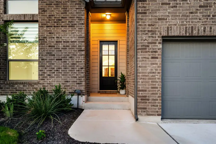 A well-maintained brick exterior with a welcoming entryway and an integrated garage.
