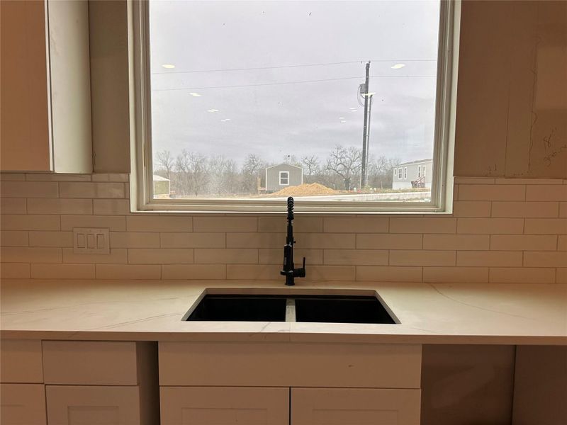 Kitchen featuring white cabinets and light stone countertops
