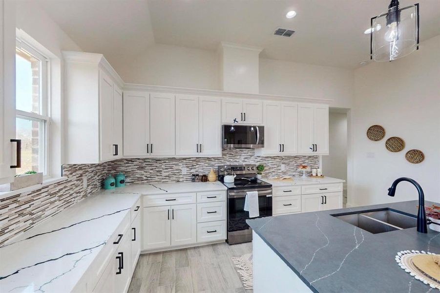 Kitchen with plenty of natural light, sink, white cabinetry, and stainless steel appliances