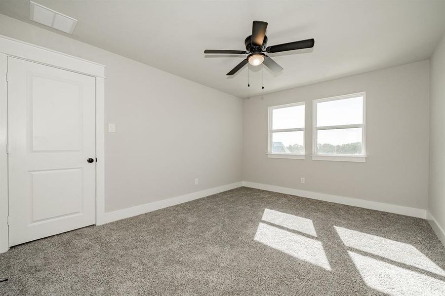 Carpeted upstairs bedroom / loft featuring baseboards and ceiling fan Carpeted upstairs bedroom / loft featuring baseboards and ceiling fan
