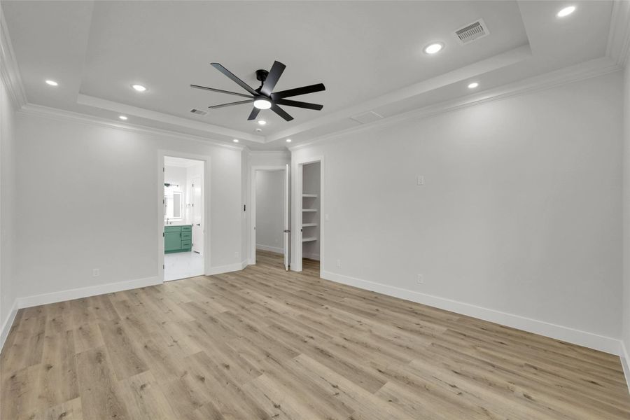 Luxurious primary bedroom retreat with tray ceiling and serene color palette Luxurious primary bedroom retreat with tray ceiling and serene color palette