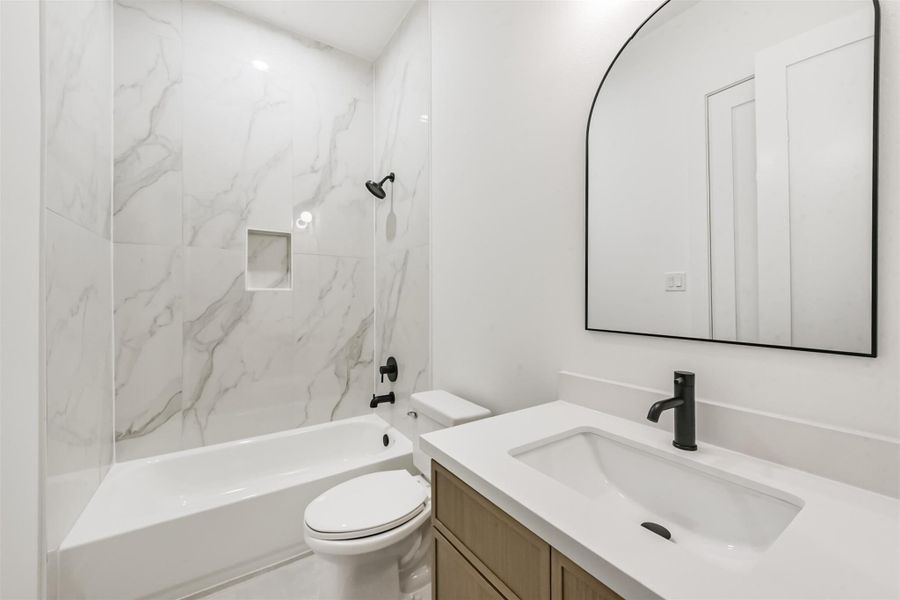 Secondary bathroom has a shower/tub combo and single sink vanity.