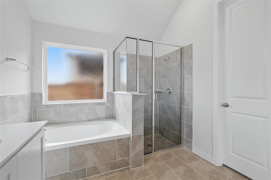 Full bathroom with a shower stall, vanity, a garden tub, and light tile patterned floors