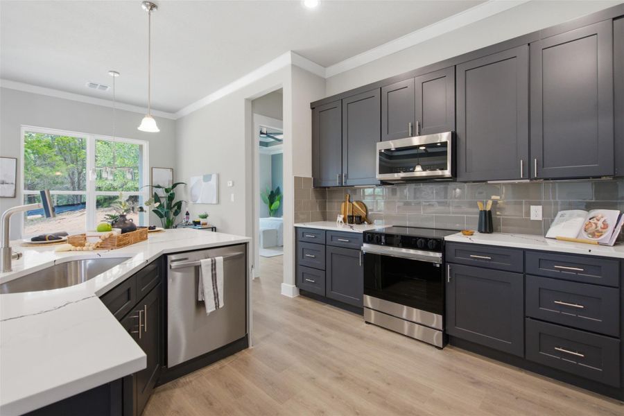 Culinary delights await in this modern kitchen with sleek dark cabinetry and gleaming stainless steel appliances. Culinary delights await in this modern kitchen with sleek dark cabinetry and gleaming stainless steel appliances.