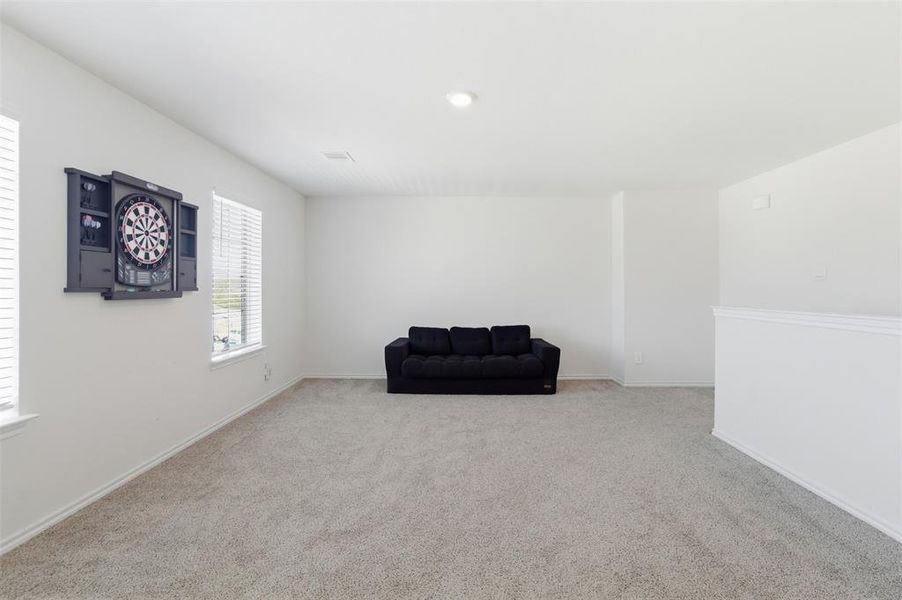 Living area featuring light carpet and baseboards Living area featuring light carpet and baseboards