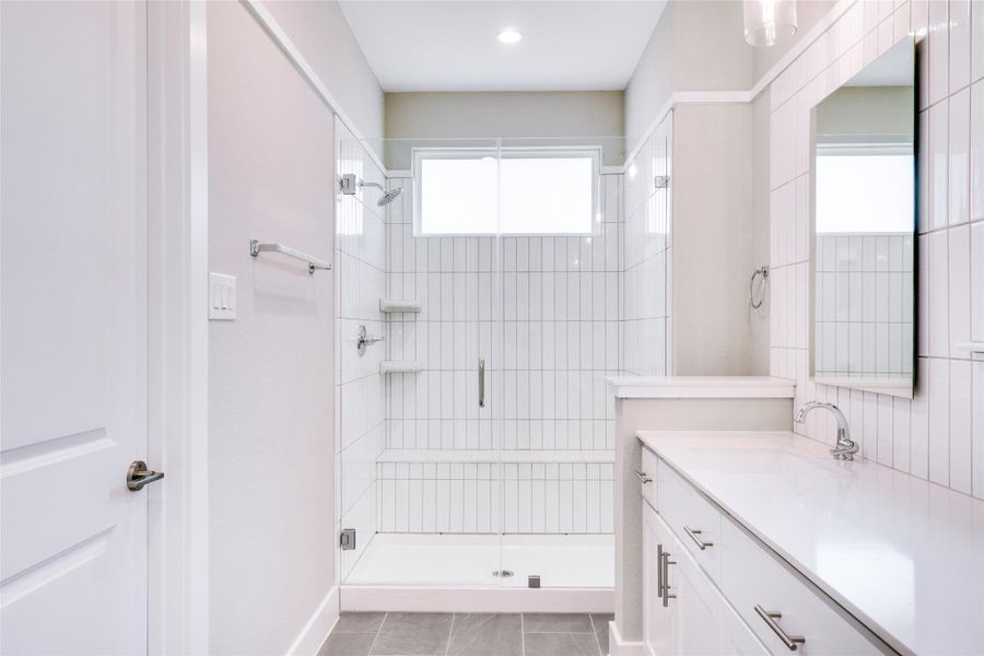 Bathroom with vanity, tile patterned floors, and a shower with door