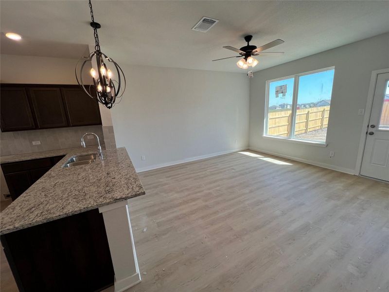 Unfurnished dining area with light wood-style floors, ceiling fan, and a chandelier