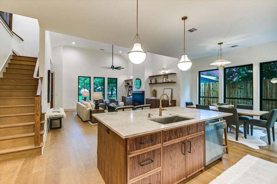 A grand staircase ascends beside an open-concept living space with high ceilings and abundant natural light. A grand staircase ascends beside an open-concept living space with high ceilings and abundant natural light.