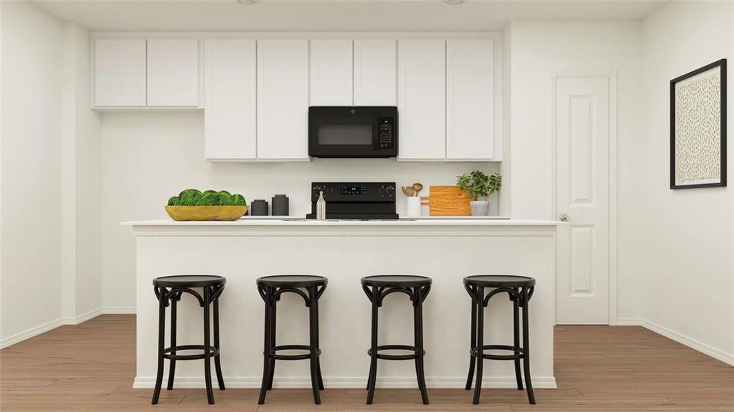 Kitchen featuring light hardwood / wood-style flooring, range, white cabinetry, and a breakfast bar area