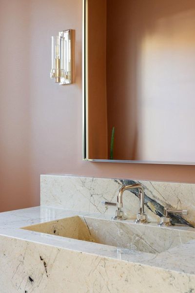 Bathroom vanity featuring a polished stone countertop and integrated sink, complete with a polished chrome faucet