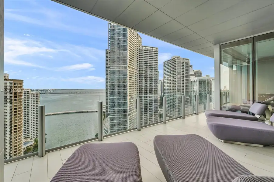 Covered terrace featuring large-format tile flooring and frameless glass balustrades Covered terrace featuring large-format tile flooring and frameless glass balustrades