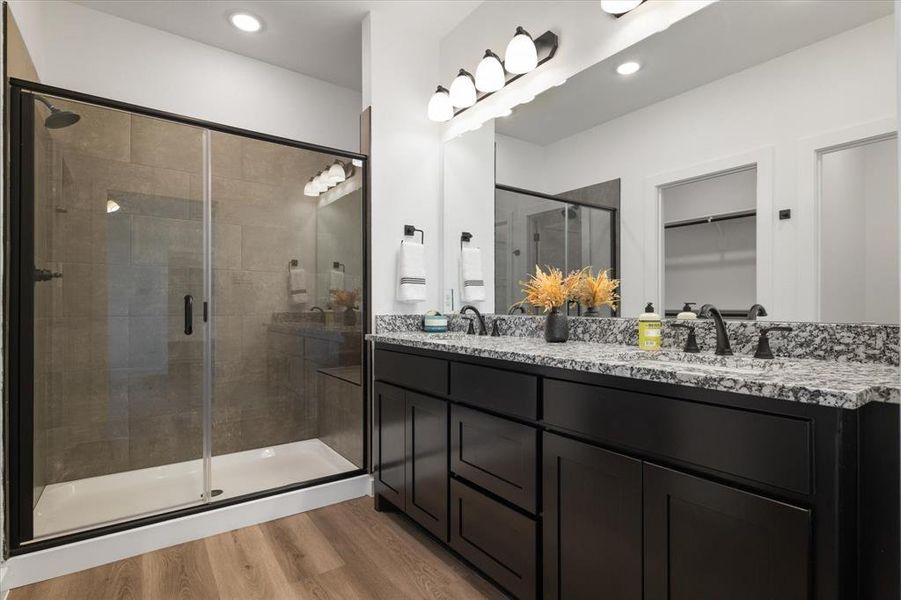 Bathroom featuring hardwood / wood-style floors, a shower with door, and vanity