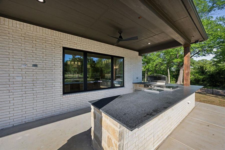 View of patio / terrace featuring a grill, an outdoor kitchen, and a ceiling fan View of patio / terrace featuring a grill, an outdoor kitchen, and a ceiling fan