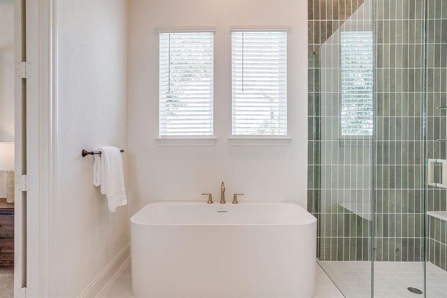 Primary bathroom with a separate shower, double vanity, level 4 Quartz countertops, and a garden tub. Primary bathroom with a separate shower, double vanity, level 4 Quartz countertops, and a garden tub.