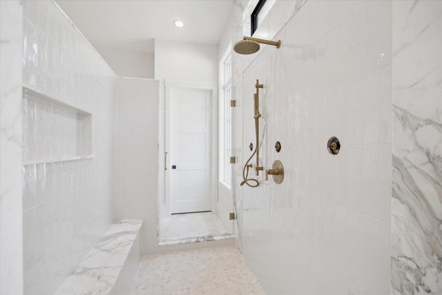Spa like primary shower with a built-in bench, and modern brass fixtures, creating a sleek and sophisticated look. Spa like primary shower with a built-in bench, and modern brass fixtures, creating a sleek and sophisticated look.