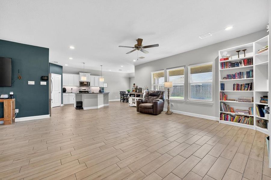 Open-concept living area featuring wood-finish flooring, recessed lighting, and a ceiling fan