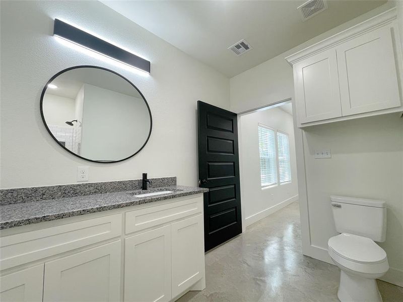 Bathroom with vanity, toilet, and concrete floors