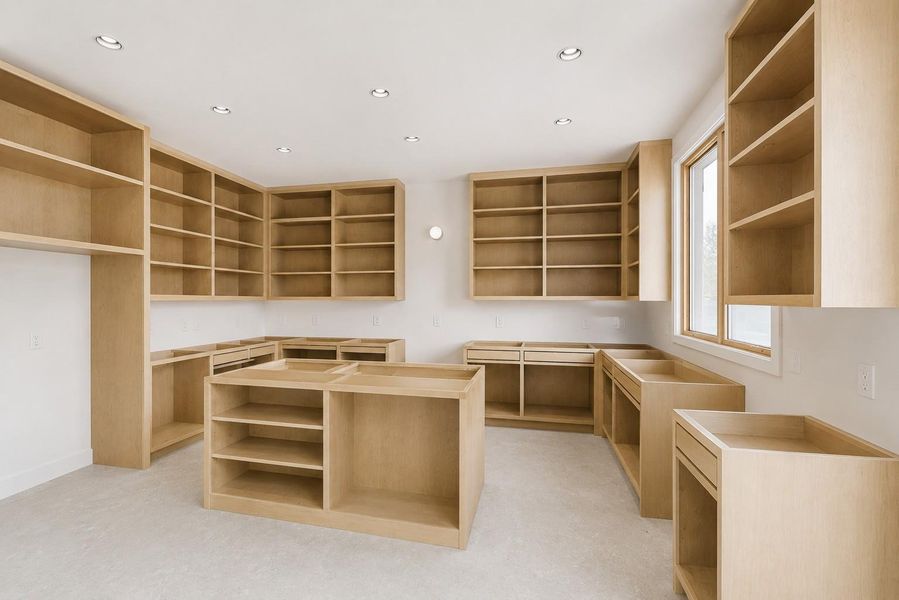 Spacious room featuring extensive built-in light wood cabinetry and shelving
