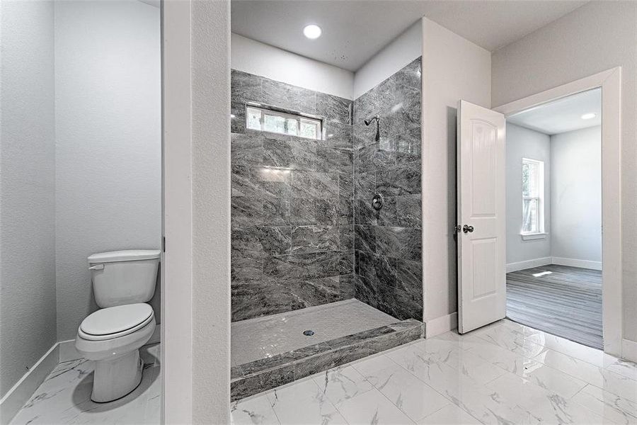 Bathroom with a tile shower and toilet