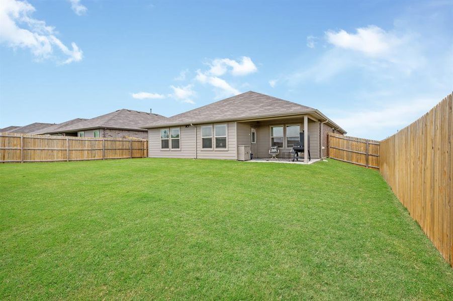 Rear view of property with a patio and a fenced backyard