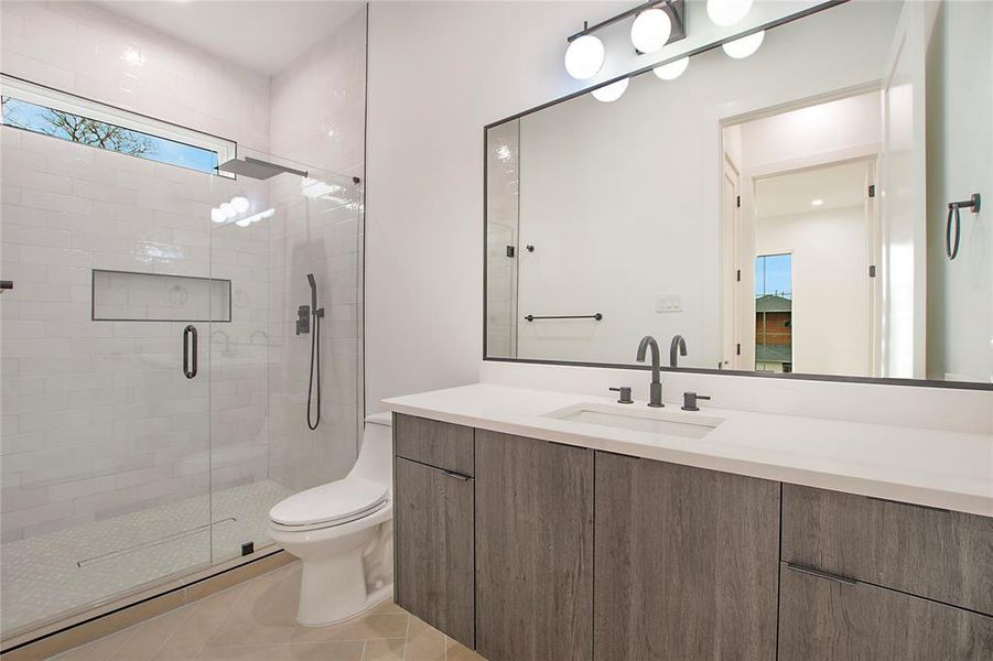 Bathroom with tile patterned flooring, vanity, toilet, and walk in shower