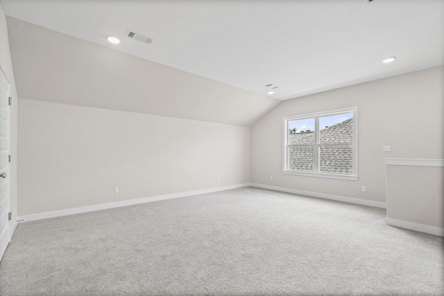 Additional living space with vaulted ceiling, light carpet, and recessed lighting